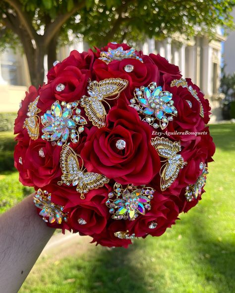 This bouquet is handmade with red roses with sparkling gold brooches.The handle of the bouquet is wrapped with satin ribbon. The design can be change if requested. I can do it in different colors. Please message me if the color is not listed.  *This bouquet is 10 inches in diameter*  If you need the bouquet sooner please sent me a message.  Please contact me if you have any questions:) Thank you so much! Red Gold Quinceanera, Red Quinceanera Bouquet, Red Theme Quince, Red Quinceanera Venue Ideas, Red And Gold Quince Theme, Red Quince Bouquet, Red Ribbon Bouquet, Red Ramos For Quinceanera, Red Quince Ring