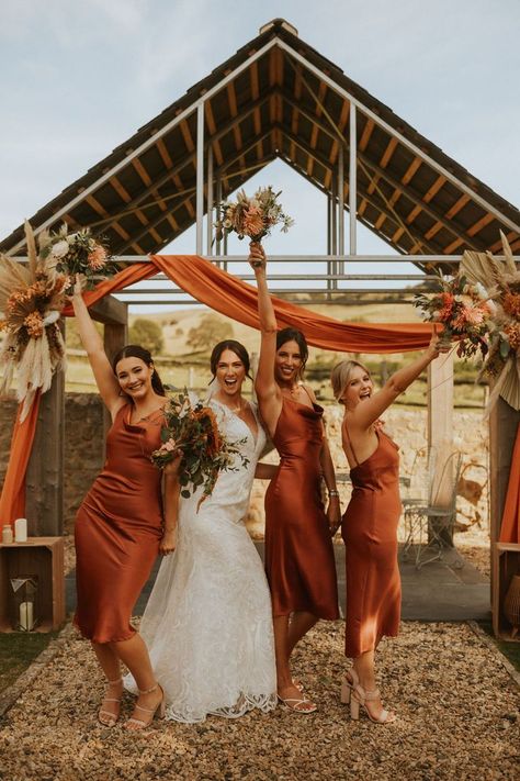 Bride in full length lace Maggie Sottero wedding dress stands with bridesmaids in orange satin bridesmaid dresses all holding up autumnal wedding bouquets. Bridesmaid Dress Boho, Slip Bridesmaids Dresses, Bridesmaid Dress Ideas, Orange Wedding Themes, Burnt Orange Bridesmaid Dresses, Orange Wedding Colors, Rust Bridesmaid Dress, Orange Bridesmaid, Color Terracota