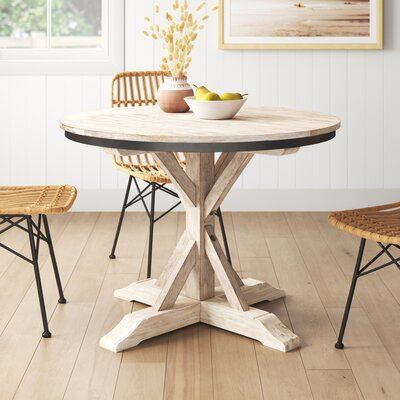 This dining table has a light, weathered look that brings tons of coastal farmhouse charm to your kitchen or breakfast nook. It's crafted from a blend of solid and engineered wood with natural wood grain that reminds us of driftwood along the ocean shore. The fixed table has a pedestal base for a classic look and a black bar around its surface for a rich color contrast. It also easily seats up to six people for happy hour or a casual weeknight meal with your family. But the best part? All the to Coastal Kitchen Table, Pedestal Dining Table Wood, Dining Table Wood, Counter Height Dining Table, Trestle Dining Tables, Wood Pedestal, Wayfair Furniture, Pedestal Dining Table, Table Wood