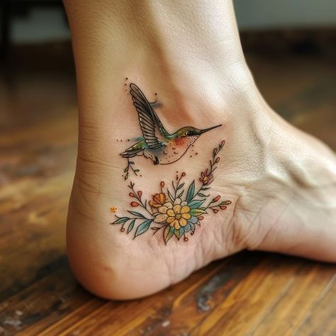 Delicate hummingbird tattoo on ankle with intricate floral design, vibrant colors, and wooden floor background. Beautiful Fish Tattoo, Spiritual Hummingbird Tattoo, Hummingbird Ankle Tattoo, Turquoise Tattoo For Women, Ankle Sleeve Tattoo, Hummingbird Tattoo Color, Hummingbird Sleeve Tattoo, Ankle Wrap Tattoo, Palm Size Tattoos Ideas