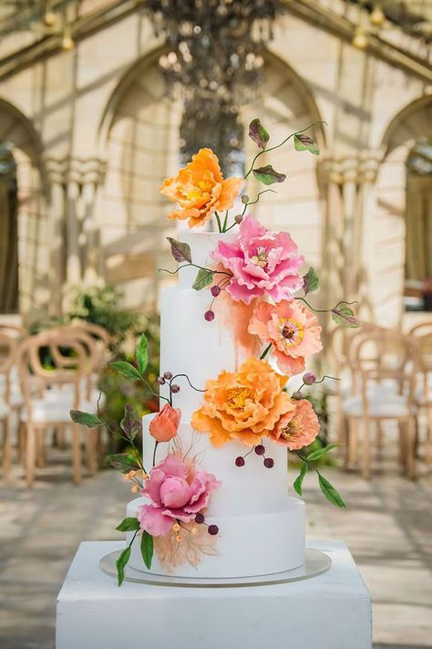 White iced wedding cake decorated with pink and orange flower decorations | Alexander Smith Stories | Pink Orange Wedding Flowers, Pink Orange Wedding, Iced Wedding Cake, Wedding Cake With Pink, Pink And Orange Flowers, Summer Wedding Cakes, Orange Wedding Flowers, Colorful Wedding Flowers, Daisy Wedding