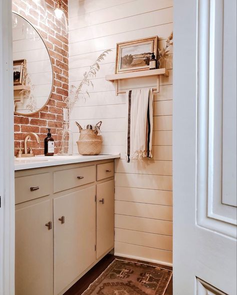 Shiplap and brick tiles were added to this farmhouse bathroom to create a more modern feel all while using elements that are found in the original architecture! Soft colors, natural wood custom built shelves and brass accents really pop against this beautiful brick wall. Brick And Shiplap Wall, Brick Bathroom Ideas, Brick Bathroom Wall, Brick Tiles Bathroom, Brick And Shiplap, White Powder Room, Powder Room Update, Brick Bathroom, Brick Accent Wall