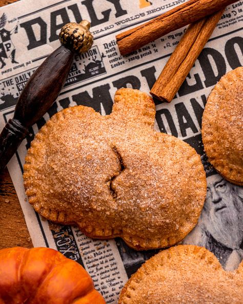 close up of a pumpkin pasty on newspaper with pumpkins, a wand and cinnamon sticks around Harry Potter Theme Snacks Food Ideas, Harry Potter Treats Easy, Hp Snacks, Pumpkin Pasties Harry Potter, Harry Potter Food Ideas, Harry Potter Dinner, Harry Potter Treats, Harry Potter Desserts, Harry Potter Snacks