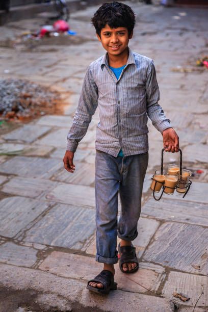 Indian little boy selling  tea - masala chai on streets of Kathmandu, Nepal. Masala chai is a beverage from the Indian subcontinent made by brewing tea with a mixture of aromatic Indian spices and herbs Indian People Photography, Human Autonomy, Pubg Png, Rapid Sketching, Cartoon Heads, Indian Street Photography, Indian Poses, India Street Photography, Bus Video