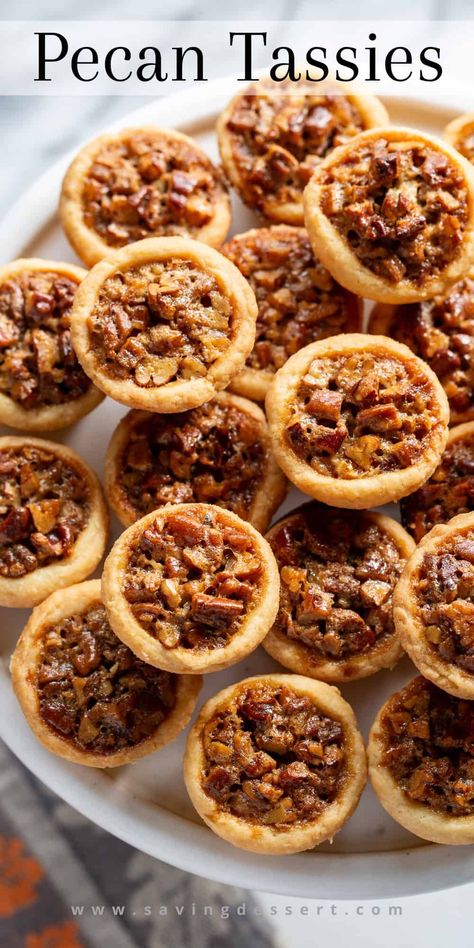 Pecan Tassies are like a mini pecan pie (but not as sweet) made with a cream cheese tart shell. They're buttery, lightly sweet, nutty and oh-so easy to pop right in your mouth! These mini pies are really great for gifting during the holidays. They freeze well and travel great. All you need is a mini-muffin tin and a mixer. #pecantassies #pecanpies #minipecanpies #pecandessert #holidaycookie #pecantassierecipe Cheese And Cracker Pie Appetizer, Pecan Tassies Recipe Taste Of Home, Mini Pie Tarts Desserts, Filipino Pecan Tarts Mini, Muffin Pies Easy Recipes, Cookies And Bars That Freeze Well, Pecan Cup Cookies, Pecan Pie Tarts Mini Phyllo, Little Pecan Pies