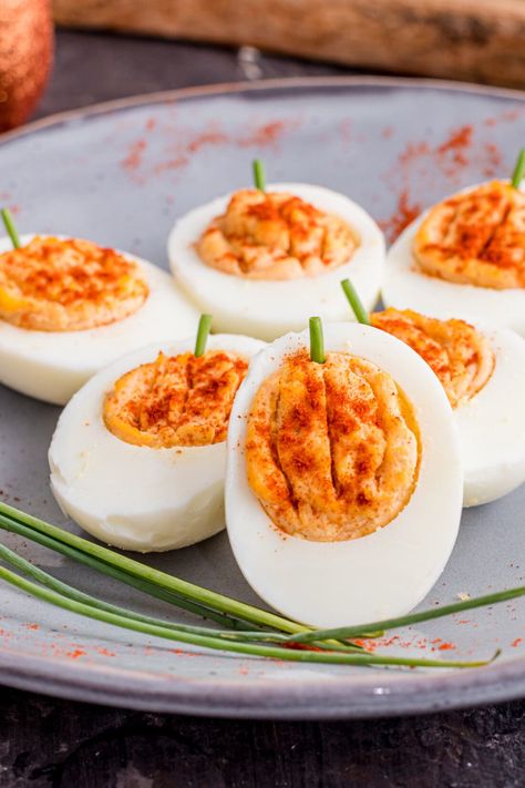 These cute little pumpkin deviled eggs are a festive spin on a classic recipe. Using all the same ingredients with the addition of paprika and chives you'll have an easy and adorable pumpkin-shaped appetizer for your fall parties! Holiday Theme Food, Pumpkin Deviled Eggs, Halloween Deviled Eggs, Thanksgiving Deviled Eggs, Healthy Deviled Eggs, Halloween Party Food Ideas, Perfect Boiled Egg, Devilled Eggs, Halloween Party Food