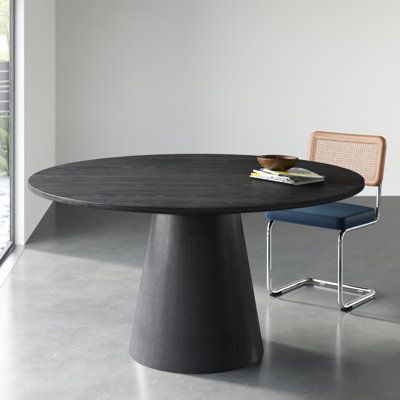 This modern round dining table brings a touch of sophistication to your dining space. With a pedestal base made from solid wood and an ebony black finish, this table adds a contemporary flair to your room. The top is crafted from engineered wood, showcasing natural wood grain color variation for a unique look. Seating up to six guests, this table is perfect for intimate gatherings or family dinners. Weighing in at 100 lbs. it offers stability without compromising on style. Wade Logan Colour: Ebo 48 Inch Round Table, Round Extension Dining Table, 60” Round Table, Oval Shape Dining Table, Mid Century Modern Round Dining Table, Modern Round Dining Room Table, Oval Marble Dining Table, 60 Inch Round Dining Table, Modern Oval Dining Table