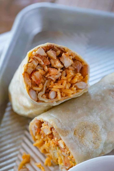 Chicken Burrito is the PERFECT grab-and-go meal made with chicken breast, Mexican rice, refried beans, cheddar cheese, and seasoning, wrapped in a flour tortilla and frozen until you need it! #chicken #chickenburrito #burrito #mexican #mexicanburrito #mexicanrecipes #dinner #dinnerthendessert Chicken Burrito Recipes, Chicken Rice Burrito, Rice And Bean Burrito, Chicken Burrito Recipe, Meals To Make With Chicken, Recipe With Rice, Burrito Recipes, Burrito Recipe Chicken, Burrito Recipe