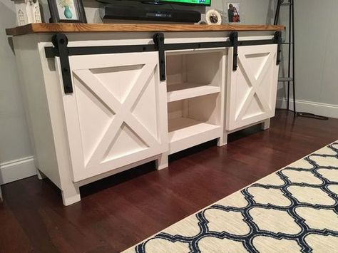 A TV stand with barn doors and shelves. Build A Tv Stand, Tv Stand With Doors, Tv Stand Plans, Barn Door Tv, Barn Door Cabinet, Barn Door Tv Stand, Tv Consoles, Diy Tv Stand, Farmhouse Tv Stand