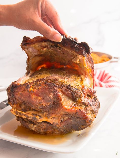 Pernil (Roast Pork Shoulder) is a staple at many Puerto Rican celebrations. Flavored with lots of garlic and herbs and topped with a crunchy chicharrón. #pernil #lechon #lechonasado #roastpork #porkshoulder #PuertoRican #Dominican #Cuban #Nuyorican #navidades #diadeacciondegracias #Christmas #tresreyes #ThreeKingsDay #Thanksgiving #holidaymeals #holidaydinner #holidays #celebrations #partyfood #crackling #chicharron #porkrind #fiesta #celebration #partyfood Spanish Pork Shoulder, Pork Shoulder Recipes Oven, Puerto Rican Roast Pork, Lechon Recipe, Roast Pork Shoulder, Spanish Pork, Puerto Rican Style, Pork Shoulder Recipes, Boricua Recipes