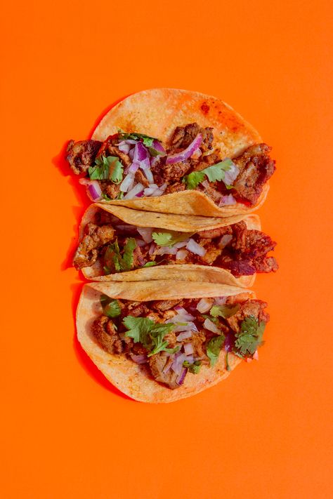 Three Al Pastor tacos on a neon orange background Food Photography Tacos, Food Photography Mexican, Taco Advertising, Taco Food Photography, Tacos Photography Food Styling, Tacos Photography, Neon Orange Background, Taco Photography, Green Enchilada Soup