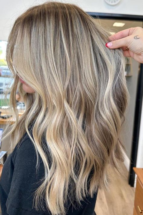 Sunkissed balayage on long layered hair creates a seamless transition from ashy brown roots to icy blonde ends, giving this look natural depth and movement. The soft waves enhance the multi-dimensional colors, ideal for adding volume to fine hair. It's a beautiful blend that works great for various occasions.  // Photo Credit: Instagram @hairby_savss Root Melt Blonde Highlights, Blonde Winter Highlights, Blonde And Brunette Highlights, Blonde Brown Lowlights, California Blonde Highlights, Blond Hair Ideas Highlights, Dirty Blonde Hair With Dimension, Bright Blonde Balayage On Brown Hair, End Of Summer Hair Color