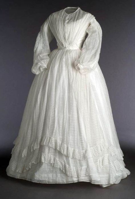 Two-piece dress, ca. 1860. White cotton muslin over white cotton taffeta. Bateau neckline front & back, decorated with lace. Hook closure in front. Museo del Traje 1860s Dresses, 1860s Fashion, Sheer Dresses, 1860 Fashion, Summer Day Dresses, 1800s Fashion, Historic Fashion, 19th Century Fashion, Old Dresses