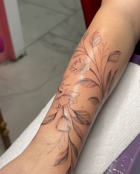 Dainty Leg Sleeve Tattoo, Peony Vine Tattoo, Flower Vein Tattoo, Magnolia Wrap Around Tattoo, Dainty Flower Vine Tattoo, Flowers On Vines Tattoo, Birth Flower Vine Tattoos, Wraparound Tattoo Forearm, Tattoos That Wrap Around Arm