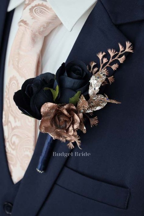 Mens lapel boutonniere with 2 navy blue rose buds accented with rose gold colored rose and filler. The stems of the flowers are wrapped in navy blue ribbon. Rose Gold And Navy Wedding Theme, Navy And Gold Wedding Flowers, Rose Gold And Navy Blue Wedding, Navy Blue And Rose Gold Wedding, Rose Gold Groomsmen, Rose Gold And Navy Blue Wedding Theme, Navy And Gold Wedding Theme, Dark Blue And Gold Wedding, Rose Gold Navy Blue Wedding