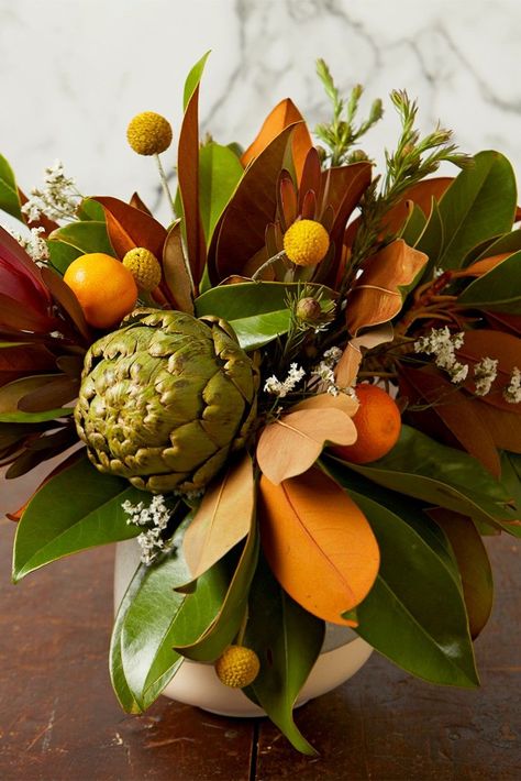 Trade a vase of fresh flowers for a fall arrangement starring artichokes, magnolia leaves, and clementines. This Thanksgiving centerpiece will look gorgeous on any Thanksgiving dinner table. #thanksgivingcenterpiece #fallcenterpiece #fall #thanksgivingdecorideas #bhg Thanksgiving Flower Arrangements, Thanksgiving Floral Arrangements, Thanksgiving Centerpieces Diy, Fruit Centerpieces, Modern Thanksgiving, Thanksgiving Floral, Thanksgiving Flowers, Mr Brown, Tree Centerpieces