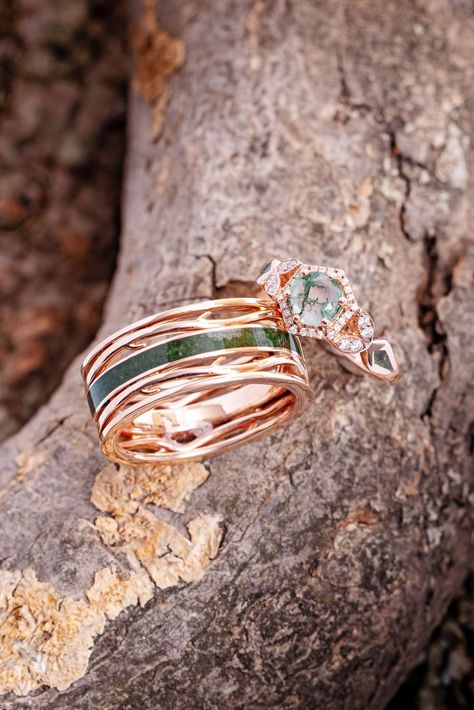 Two unconventional wedding rings from Staghead Designs sit on a tree branch. This unique men's wedding band is our "Artemis" design in 14K rose gold with antler/branch style details & a centered inlay of real moss encased in resin. The women's engagement ring is our "Lucy In The Sky Petite" moss agate engagement ring in 14K rose gold with a diamond halo, floral diamond accents, & real moss inlays on the sides. Men's Unique Rings, Woodland Fairy Engagement Ring, Mens Engagement Rings Unique, Earthy Wedding Bands, Moss Wedding Ring, Earthy Wedding Rings Men, Fairy Wedding Band, Moss Agate Engagement Ring Men, Mens Moss Agate Wedding Band