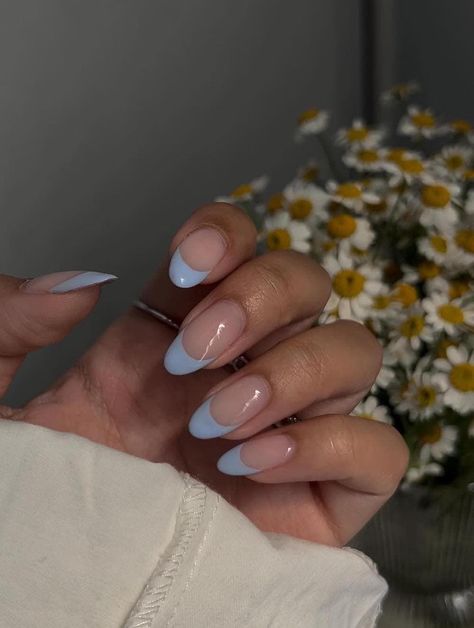 A hand with medium long nude nails painted with light blue French tips #womensfashion #naildesign #springnails #nails #naildesigntrends Spring Nails 2024 Trends French, Simple Almond Acrylic Nails, Pastel Blue Nails, Blue Prom Nails, Ladybug Nails, Almond Acrylic, Blue French Tips, Light Blue Nails, Nude Nail Designs