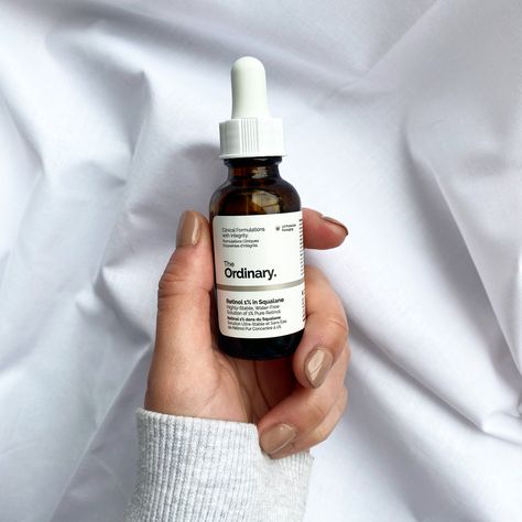 The Ordinary 1% Retinol in Squalane held with a hand with painted nails against a white cotton backdrop. Ordinary Skincare Aesthetic, Ordinary Aesthetic, Serum Aesthetic, Ordinary Retinol, Aesthetic Skincare Routine, The Ordinary Retinol, Oil Texture, Nighttime Skincare Routine, Ordinary Skincare