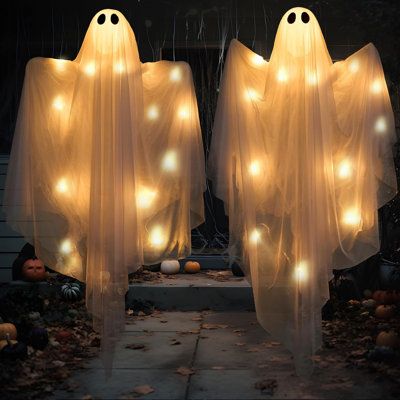 Ghoulishly Good Decorations: Elevate your Halloween d茅cor with our Hanging Light up Ghost. Whether hung indoors or outdoors, its spooky presence is sure to make a hauntingly delightful statement. From haunted house themes to spooky yard displays, it's the perfect accessory for adding a touch of special magic to your festivities. Get ready to delight and terrify your guests with our Halloween Hanging Light up Ghost - because every Halloween celebration deserves a good scare! The Holiday Aisle® | Halloween Yard Themes, Diy Light Up Ghost Decoration, Diy Halloween Light Up Ghost, Light Up Porch Ghosts, Halloween Dance Decorations, 18th Decorations, Dancing Ghosts In Yard, Haunted House Themes, Halloween Light Decorations