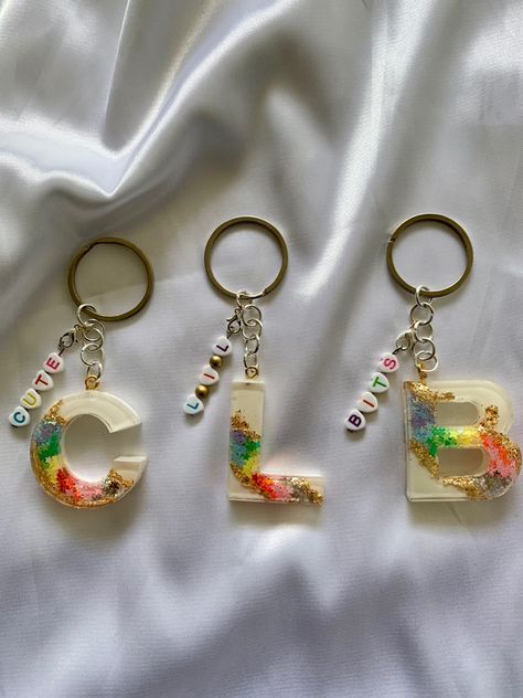 This  is a resin keychain, with a rainbow geode design, made from star shaped iridescent/opal glitter, on a white background. Keychain includes a custom name charm, made with rainbow colour letter beads. S Letter Resin Keychain, Rainbow Resin Keychain, Glitter Resin Keychain, Name Resin Keychain, Resin Letter Keychain Ideas, Resin Name Keychain, Letter Resin Keychain, White Glitter Background, Rainbow Geode