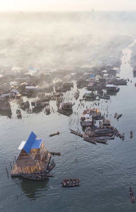 NLÉ | 'Makoko Floating School' | Makoko is a old, sprawling shanty town supported on stilts above the waterfront of Lagos, Nigeria. Increasingly battered by rising seas, the settlement was becoming dangerous, and the government forcibly cleared part of it last year. Kunle Adeyemi, a Nigerian architect, had a better idea. He and his team devised a floating school that provides a flexible and robust prototype for housing and other potential structures. | Lagos, Nigeria | 2013 | www.nleworks.com/ Architectural Review, Floating Architecture, Sea Shanties, Shanty Town, Floating City, Sea House, Lagos Nigeria, Photography Contests, Save Animals