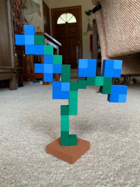 Minecraft blue orchid flower made of small wooden blocks painted. Green stem with 6 blue flowers. Terracotta brown square base at the bottom. Painted Minecraft Blocks, Minecraft Flower Out Of Blocks, Minecraft Blue Orchid Flower, Minecraft Block Painting, Small Diy Wood Gifts, Blue Orchids Minecraft, Wood Block Minecraft Flower, Wood Block Pixel Art, Minecraft Flower Cubes