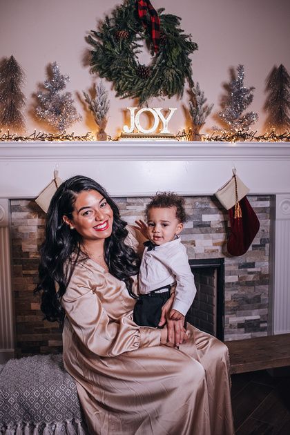 mother holding son sitting on bench in front of fireplace Family Photos In Front Of Fireplace, Family Pictures In Front Of Fireplace, Family Christmas Pictures In Front Of Fireplace, Inside Christmas Photo Shoot Family, Christmas Tree Photoshoot Family Home, At Home Christmas Photoshoot Family Fireplace, Fireplace Family Photoshoot, Christmas Mini Sessions Fireplace, I’m Home Family Christmas Photos