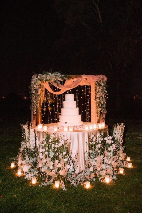 wedding cake display surrounded by flowers Outdoor Wedding Cake Table Ideas, Romantic Wedding Cake Table, Wedding Flower Display Ideas, Simple Cake Backdrop, Unique Wedding Cake Display, Outdoor Wedding Cake Table, Cake Displays For Weddings, Wedding Cake Display Table Elegant, Wedding Cake Area Decoration