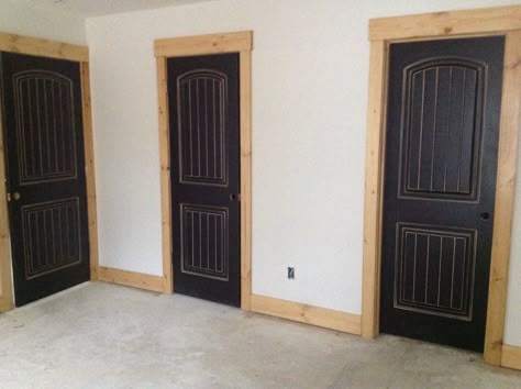 Black distressed doors with natural wood frame & trim in parent's lake house. Distressed Interior Doors, Distressed Black Interior Doors, Stained Door Frames, Modern Rustic Interior Trim, Stained Pine Trim Interior, Wood Trim Door Frame, Black Interior Doors With Stained Trim, Black Stained Doors Interior, Interior Door Colors Wood Trim