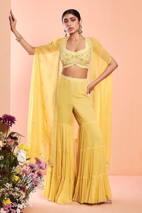 Buy #daisy #yellow embroidered cape with scallop hem. Paired with dabka embroidered blouse and tiered sharara by #NiamhbyKriti at #AzaFashions Shop online now at #Azafashions.com Call +91 8291990059 or email contactus@azafashions.com for enquiries. #wedding #festive #ethnic #tradional #shopping #shoponline #party #reception #bride Women Haldi Outfit, Cape Sharara, Yellow Sharara, Sharara Designs, Beaded Cape, Embroidered Cape, Sharara Pants, Daisy Yellow, Pearl Work