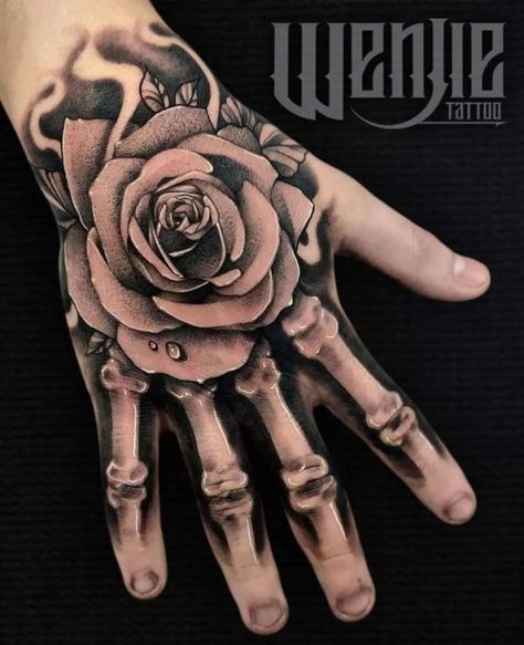 Rose skeleton hand tattoo with water drop on petal Rose Hand Tattoo With Skeleton Fingers, Skeleton Hand Tattoos With Rose, Hand Tattoos For Guys Skull, Tattoo Ideas For Hands Men, Skellington Hand Tattoo, Mens Skeleton Hand Tattoo, Arm To Hand Tattoo Men, Hand Tattoos For Guys Stencils, Hand Tattoos Men Ideas