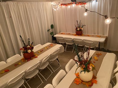 I decided to host Thanksgiving for about 15 people in my 1300 sq ft home. Being limited on space I decided to convert the garage into an extended dinning room. This setting was for 20 people. I rented the pipes and drapes, tables and chairs. It was expensive but definitely saved me time from doing it myself. It is however, totally doable on your own. With the addition of some decorations and lights it converted the space into a beautiful and elegant setting. Dinner Table Thanksgiving Decor, Thanksgiving Dinner Outfits 2023, Thanksgiving Garage Decorations, Dinner Party For 20 People Table Settings, Thanksgiving Table Settings For 20 People, Thanksgiving Dinner Centerpieces Diy, Simple Easy Thanksgiving Table Decor, Thanksgiving Friendsgiving Decorations, Thanksgiving Dinner Set Up Ideas