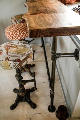 The breakfast counter is simply a wood slab that sits on a thrifty but attractive base made of plumbing pipes. Swiveling iron stools were scored at the Long Beach flea market for $200 and then upholstered in outdoor fabric. Island Bars, Budget Design, Iron Stools, Revere Pewter, Plumbing Pipes, Into The Wood, Pipe Furniture, Kitchen Islands, Into The Woods