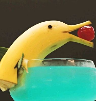 This banana dolphin is ready to party! Featured on Completely Coastal. Tiki Garnish, Beach Party Food, Drink Garnish, Pineapple Leaves, Miami Party, Tropical Drinks, Drink Garnishing, Tiki Drinks, Tiki Cocktails