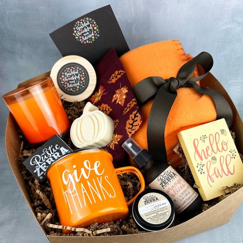 My gift boxes make the perfect gift! Each box measures 10"x10"x6", is tied with orangewhite bakers twine and is ready to give as a gift to that special person. Gift box includes: (1) 7 oz natural, hand poured, soy candle in orange jar with wooden lid in your choice of scent (1) custom box of matches (1) pair of fall socks (1) 50"x60" orange fleece blanket (1) small fall wooden sign (1) 2 oz orange slices linen spray (1) small pumpkin pie lotion bar (1) fall 12 oz coffee mug (1) pumpkin shaped go Fall Gift Box Ideas, Small Pumpkin Pie, Fall Gift Basket Ideas, Fall Basket Ideas, Fall Baskets, Pumpkin Lotion, Spa Baskets, Thanksgiving Gift Basket, Thanksgiving Baskets