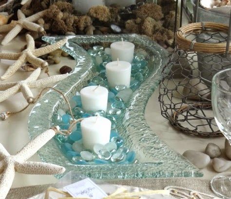 Top Coastal Candle Centerpieces for a Warm & Festive Table..wavy bubble glass..looks like a steam of water with pebbles. Coastal Centerpiece, Coastal Candle, Seaside Decor, Beach Theme Decor, Beachy Decor, Beach House Interior, Coastal Christmas, Centerpiece Ideas, Festive Tables