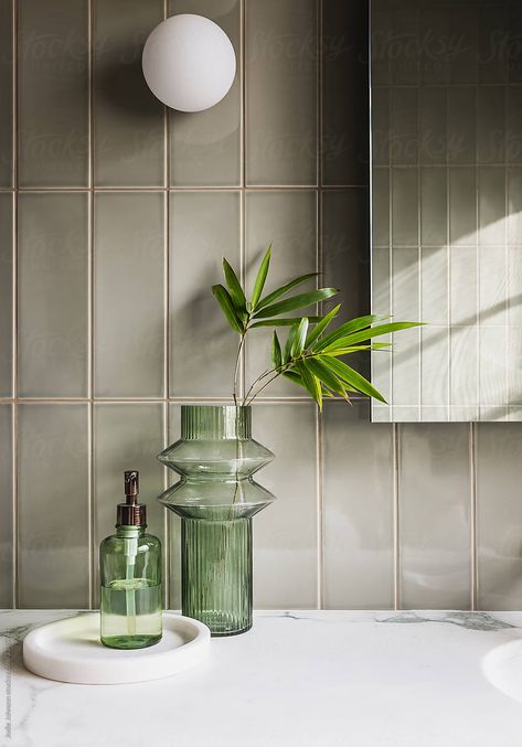 Green vertical stacked subway tiles with orb wall light and glass decor items Non Tiled Bathroom, Wow Tiles Bathroom, Bathroom Decor Items, Vertical Kitchen Tiles, Light Green Bathroom Tile, Green Vertical Tile, Stacked Tile Shower Wall, Apartment Decor Green, Vertical Stacked Tile