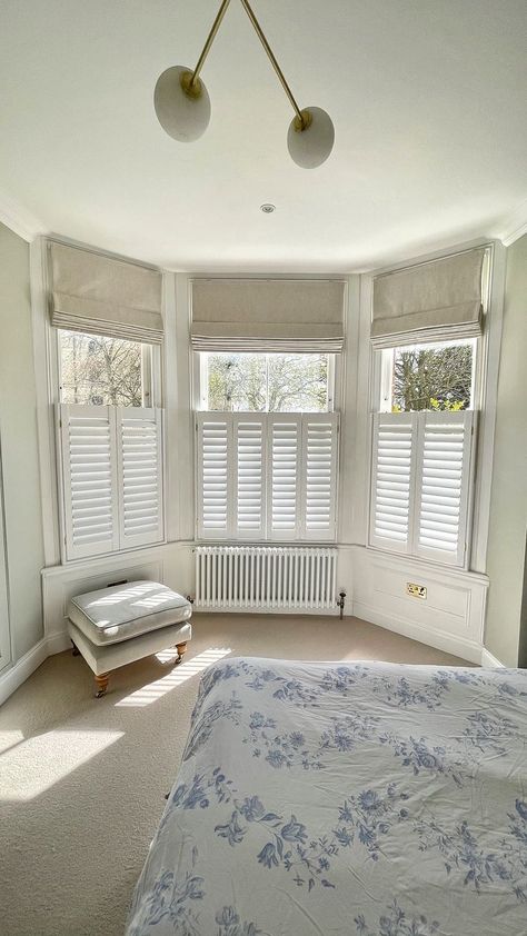 This combination of cafe-style shutters and Roman blinds is just beautiful!  

The cafe-style allows for privacy throughout the day, with the roman blinds in Sila Birch, adding privacy by night with a touch of style!  

The roman blinds also have a blackout interlining allowing increased darkness at night and one which is commonly required with lighter mornings and evenings during Spring and Summer. Roman Blinds Bay Window, Shutters With Curtains, Bedroom Shutters, Cafe Shutters, Cafe Style Shutters, Shutters Living Room, Bay Window Living Room, Grey Interiors, Bedroom Blinds