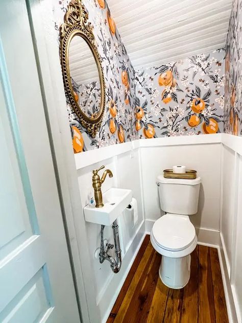 a chic and tiny under the stairs powder room with bold wallpaper and paneling, a wall mounted sink and a mirror in a vintage frame Minimalist Powder Room, Understairs Toilet, Tiny Half Bath, Tiny Powder Rooms, Room Under Stairs, Tiny Powder Room, Small Powder Room, Small Downstairs Toilet, Bathroom Under Stairs