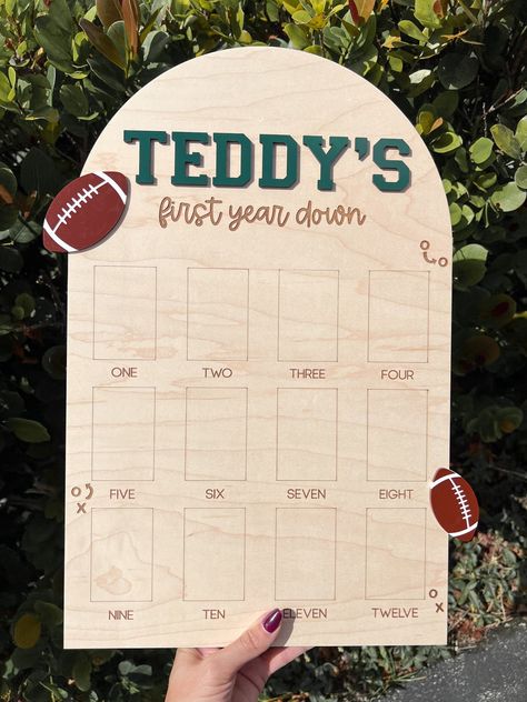 This beautifully crafted one year down photo board is the perfect way to commemorate your little one's first year! Names are 3D done in dark green wood, footballs are down in brown and white acrylic, all other elements are perfectly engraved.  Show off your baby's 12 monthly milestones on one of our first year picture board.  This is perfect to display at a birthday party and keep as a room décor after.   DETAILS * Sizing options are shown in photos (all board will be FOOTBALL boards, the size p Football First Birthday Party Ideas, First Down 1st Birthday Party, First Year Down Birthday Party Food, My Rookie Year First Birthday Football, 1st Down Football Birthday Party Food, One Year Old Football Birthday Party, First Year Down Football Birthday Food, One Year Party Theme, Rookie Year First Birthday Football