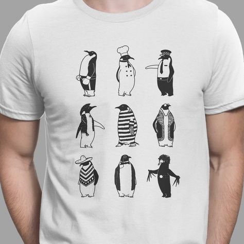 'PENGUINS' T-shirt by Gamma Ray Designs   Can you spot which job each penguin does? Yes, the last penguin is indeed Edward Scissorhands, so I guess he's the only one without a job. This black and white minimalist t-shirt is clever, conceptual, and kinda cute. Anyone who loves birds, animals, and wildlife is bound to appreciate this quirky tee, plus everyone loves interactive designs where you have to guess who is who. :-)   This is a premium, fitted, short-sleeve, men's cotton graphic tee that i Penguin Polo Shirt Men, Casual Crew Neck T-shirt With Bird Print, White Cotton T-shirt With Fish Print, Casual Cotton T-shirt With Shark Design, Nature Tees, Penguin T Shirt, Animal Tshirt, Cute Penguins, Men Short Sleeve