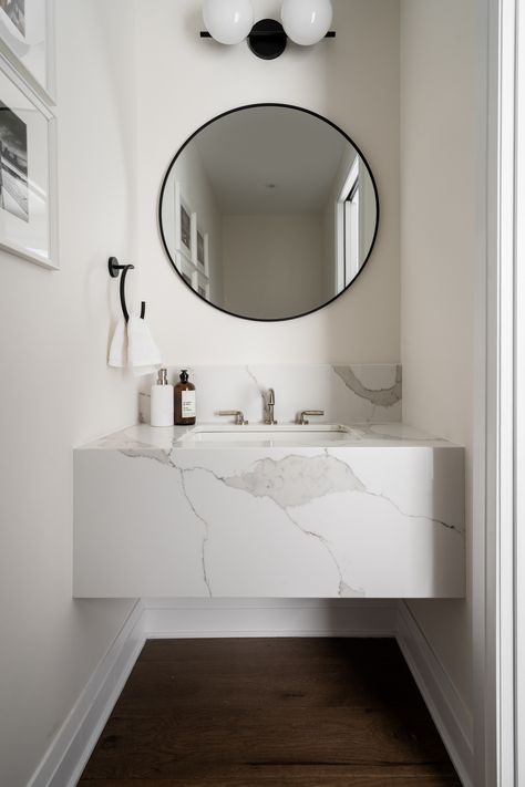 A sleek marble floating vanity with a round black-framed mirror in a minimalist bathroom. Simple decor includes a hand towel and natural light, creating a clean and stylish look. Marble Floating Vanity, Vanity With Round Mirror, Vanity Design Ideas, Aesthetic Pin, Black Mirror Frame, Vanity Design, Marble Surface, Floating Vanity, Of Montreal