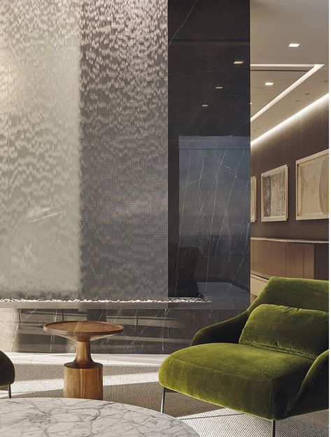 Mesmerizing ripples of water emanate from a discrete slot in the lounge area ceiling of this sophisticated office space in Downtown Los Angeles. Measuring 16 ft. wide by 12 ft. tall the Water Veil is positioned in front of a large glass wall to promote multiple viewing perspectives. The water disappears into a bed of black beach pebbles bordered on two sides by a built-in marble bench that creates an ideal location to enjoy the peaceful sound and sight of this unique Water Veil. Water Ripple Ceiling Design, Water Wall Interior, Lobby Water Feature, Office Waterfall, Indoor Water Wall, Indoor Waterfall Wall, Marble Bench, Water Room, Glass Waterfall