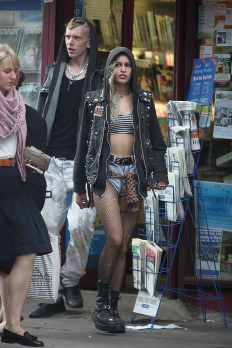 Super edgy sleaze punk fashion from Alice Dellal, wearing a cutoff leather jacket, denim shorts, ripped fishnets and grungy combat boots Ripped Fishnets, Alice Dellal, Style Combat Boots, Punk Rock Style, Punk Style Outfits, Punk Rock Outfits, Estilo Indie, 90s Fashion Grunge, Rock Outfits