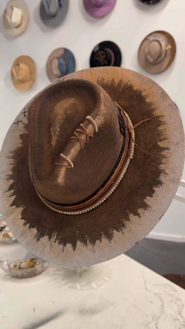 Alexa Wisnieski on Instagram: "Penny Pincher . . Paint inspo @jerseydayclub . @travisaustincustoms . #hat #hatmaker #artist #creative #creator #hatmaking #hatmakingvideo #process #creativeprocess #art #paint #painting #nashville #nashvilletn #tn # #feltseason #westernfashion #westernstyle #western #mixedmetals" How To Paint A Felt Hat, Unique Cowboy Hats, Diy Hatbands, Cowboy Hat Decorations Ideas, Felt Hat Burning Designs, Custom Hat Ideas, Painted Cowboy Hats, Hat Bands Diy Ideas, Hat Decorating Ideas