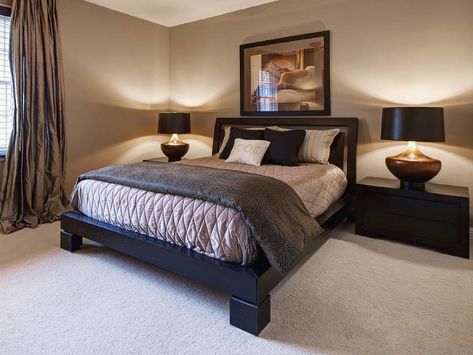 A heavy platform bed anchors this beige bedroom featuring soft lighting, black nightstands and silk drapes. Black And Beige Bedroom, Beige And Black Bedroom, White And Beige Bedroom, Beige Inspiration, Beige Bedroom Ideas, Beige Bedroom Decor, Black Bedroom Design, Contemporary Bedroom Design, Bedroom Design Inspiration