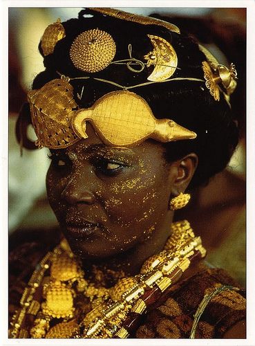 "In Ghana, the display of gold at the Ashanti's king jubilee in 1995 was unsurpassed in splendor. This Adioukrou Queen mother, attending the jubilee, indicates her status by wearing gold turtle and crocodile talismans in her hair. Bedecked with gold jewelry and gold dust makeup, she exhibits her husband's authority and worth. photo: Carol Beckwith and Angela Fisher" Black Royalty, African Royalty, African People, Queen Mother, African Queen, We Are The World, African Culture, World Cultures, African Beauty