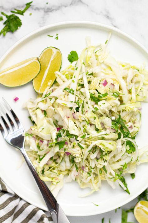 This Cilantro Lime Slaw is the perfect addition to any taco! Crisp, crunchy, and, tangy, it comes together in about 5 minutes and is loaded with all real ingredients - and NO MAYO! This slaw is tossed in a Mexican-inspired lime vinaigrette which leaves it tasting light, zesty, and refreshing! Slaw For Tacos, Lime Slaw, Cilantro Lime Slaw, Savoy Cabbage, Lime Vinaigrette, Beetroot Salad, Vegetarian Side Dishes, Vegetarian Cabbage, Mexican Dinner