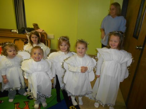 Angel costumes made out of plastic tablecloths from Dollar Tree. Tablecloths are cut down the middle (length wise) then cut across for the height for the child. These draped over the children. I cut a space for the head to go through, glued (school glue) tinsel on the bottom and tied strips of tulle around the waist. Wings were made from poster and tinsel. Angel halos were made from wire garland and curly ribbon (ribbon for girls). These were worn over white shirts & pants with socks. Precious!! Angel Halos, Angel Costumes, Christmas Skits, Best Christmas Pageant Ever, Christmas Sunday School, Christmas Sunday, Nativity Costumes, Angel Halo, Christmas Pageant